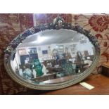 A 20th century gilt wood oval mirror with floral border and bevelled plate, 60 x 82cm