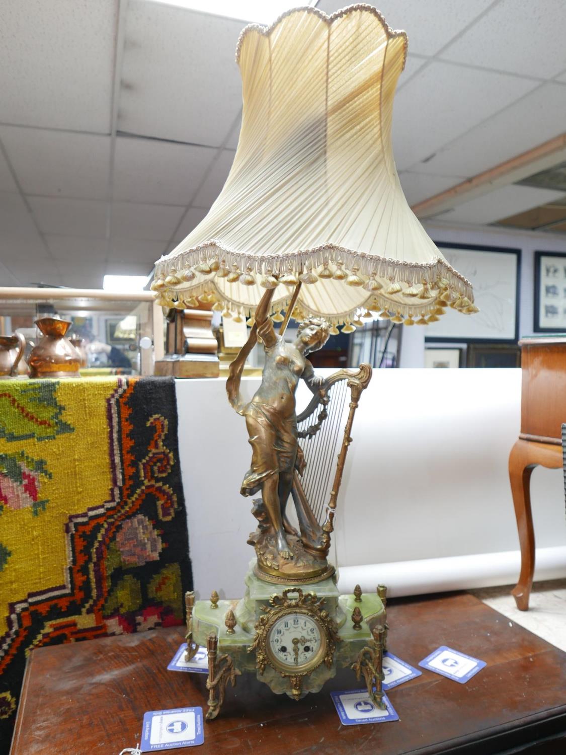 A late 19th century French style gilt spelter and onyx mantel clock with lamp held aloft (some