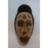 An African Punu tribal mask, with white patina and scarification, H.40cm
