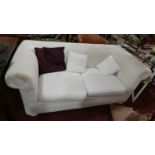 A cream upholstered Chesterfield style sofa. L.170cm