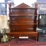 A Victorian mahogany waterfall bookcase on stand, with two drawers raised on turned legs and