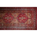 A 20th century Persian runner with five pole geometric medallion, on a red and beige ground,