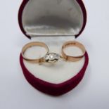 A red velvet heart-shaped box comprising of a 9ct rose gold band Size L, 1.3g, a 9ct yellow gold