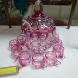 A pink glass punch bowl and cover, H.35cm, with twelve matching cups, together with an associated
