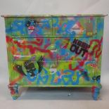 A 20th century chest of drawers painted with graffiti, H.80 W.90 D.45cm
