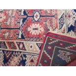 A hand-made Persian red ground rug, geometric motifs on red ground, within geometric border on a