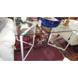 A glass topped low table on metal tubular base. W.139 D.82cm