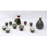 Two Japanese sake jars and a collection of sake cups