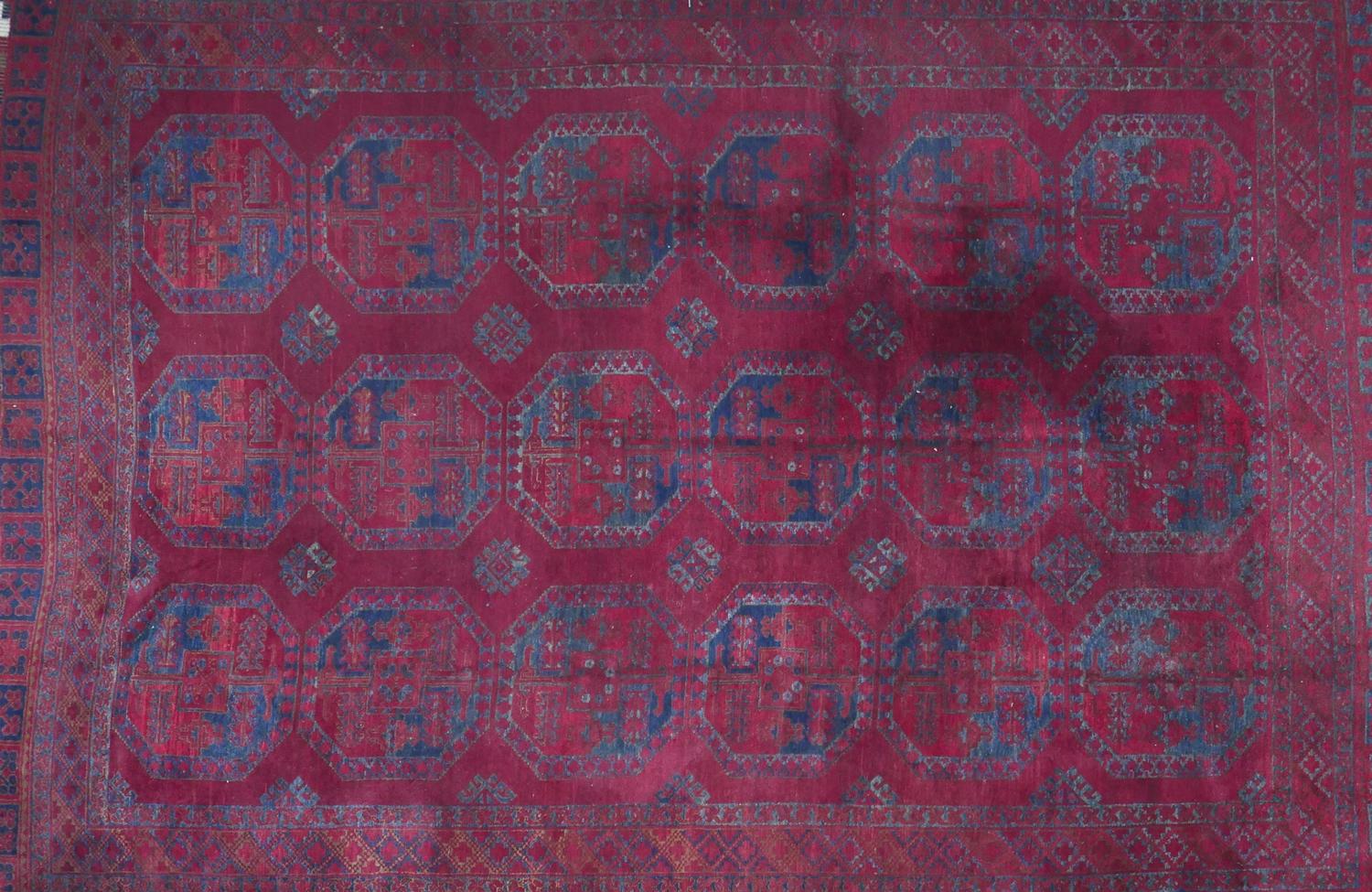 An antique Russian Afghan bokhara carpet, with large gull motifs, on a red ground, contained by