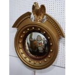 A Regency style gilt convex wall mirror with eagle surmount. H,67 W.57cm