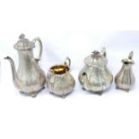 A Victorian silver four piece tea set, with engraved floral decoration, scroll feet and gilt