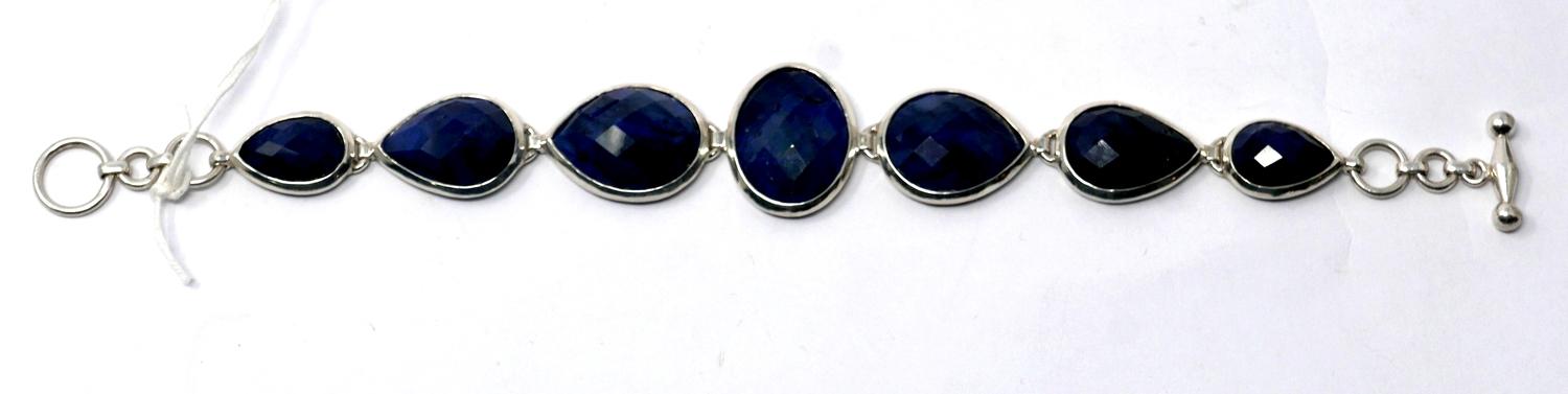 A sterling silver and natural sapphire bracelet composed of six graduated tear-drop sapphires and