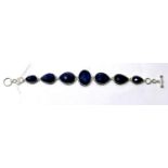 A sterling silver and natural sapphire bracelet composed of six graduated tear-drop sapphires and