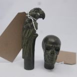 A bronze walking cane handle in the form of a parrott and a similar of a skull. L.13cm