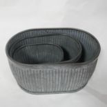 A set of 3 graduating galvanised metal garden planters. Largest; H.34 L.63cm