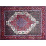 A Persian Quashqai rug with central graduating geometric medallion, on a red, blue and beige ground,