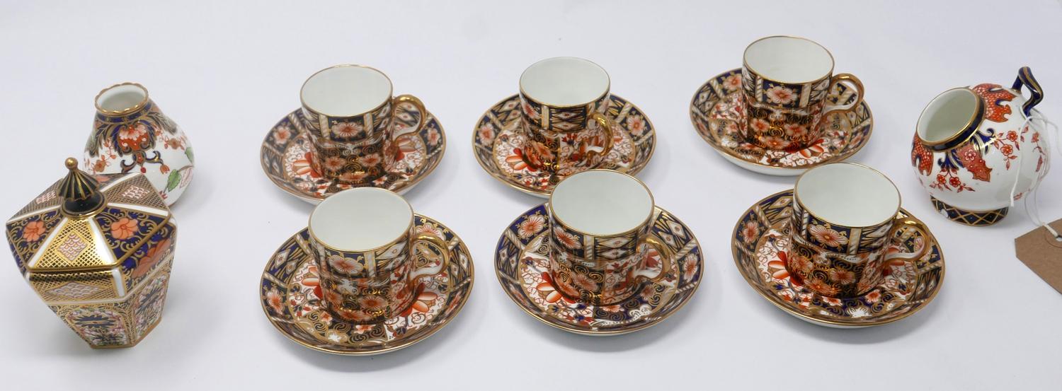 A set of six Royal Crown Derby coffee cups and saucers together with two small vases and a pot