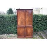 An early 19th century mahogany 2 section bookcase with flame mahogany fielded panel doors fitted