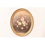 An oval gilt framed oil on board of flowers. H = 49cm W = 40cm