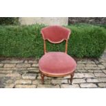 A Victorian mahogany nursing chair in rose velour upholstery on squat turned supports. H = 75cm