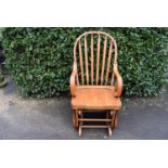 A light oak Windsor style spring action rocking chair, H = 111cm W = 58cm D = 52cm