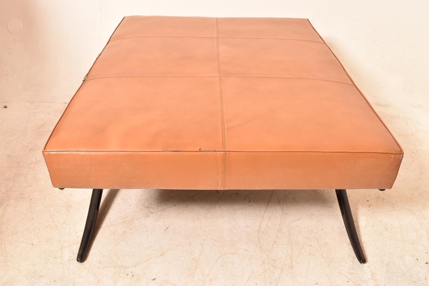 A large modernist leather stool in tan leather, H = 46cm W = 125cm D = 92cm (some scuffs to leather)