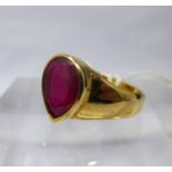 A 9ct yellow gold and ruby ring, centrally collet-set with a large, faceted, pear-drop ruby to