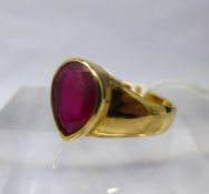 A 9ct yellow gold and ruby ring, centrally collet-set with a large, faceted, pear-drop ruby to