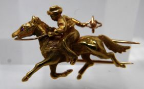 An 18ct yellow gold horse and rider brooch with ruby eye to horse, 2.5 x 4cm, 9.1g