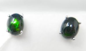 A boxed pair of sterling silver, black opal cabochon stud earrings (flashes of green and red), Opal: