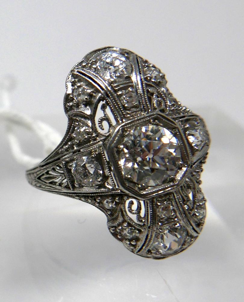 An 18ct white gold, Art Deco ring set with a large brilliant-cut diamond radiating to a further 8