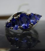 A boxed 14ct white gold tanzanite ring set with five graduated oval faceted natural tanzanite stones