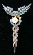 A yellow gold, caduceus style brooch pave-set with turquoise and diamonds and centrally-set with a