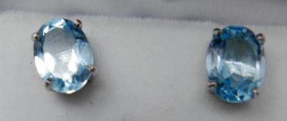 A boxed pair of sterling silver and oval, blue topaz stud earrings, 8 x 6mm, 1.6g.