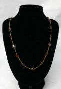 A 14ct yellow gold chain necklace interspaced with twenty-two, oval, natural faceted garnets, L: