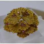 An 18ct yellow gold, flower-head brooch composed of eighteen gold petals studded with a total of