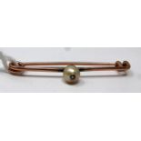 A Victorian, rose gold bar pin brooch centrally set with a natural pearl inset with a rose-cut