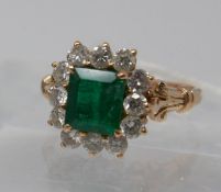 A Boxed, 18ct yellow gold diamond and emerald cluster ring, the central, stepped-cut emerald (6 x