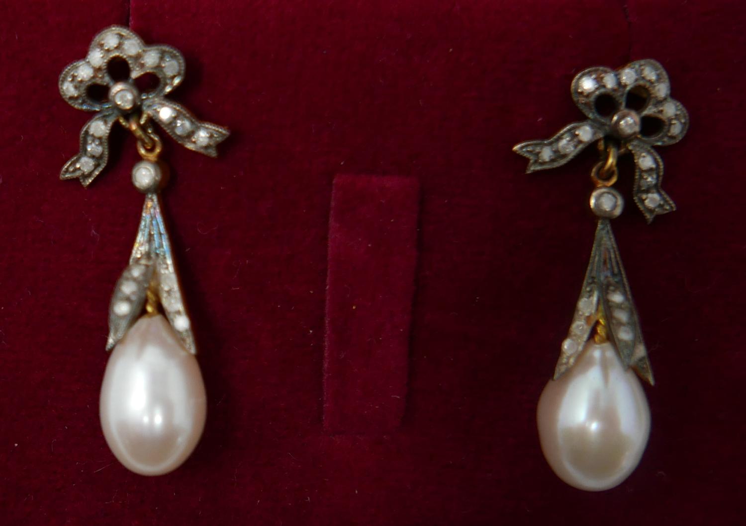 A boxed pair of antique yellow gold earrings set with diamond-studded bows to a pearl drop, 3.5 x