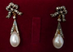 A boxed pair of antique yellow gold earrings set with diamond-studded bows to a pearl drop, 3.5 x