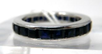 An 18ct white gold and callibre-cut sapphire ring composed of 24 natural sapphires in a channel-