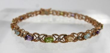 A 9ct yellow gold tennis bracelet alternately set with faceted citrines, peridots, amethysts,