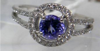 An 18ct white gold and tanzanite ring, composed of a central, circular facteted, tanzanite to a halo