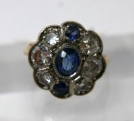 An Art Deco, 18ct yellow gold and platinum, diamond and sapphire cluster ring set with a central