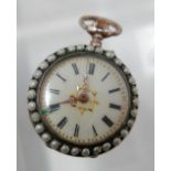 A white metal and seed pearl open face fob watch, the enamel dial with Roman numerals, gilt out