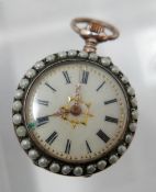 A white metal and seed pearl open face fob watch, the enamel dial with Roman numerals, gilt out