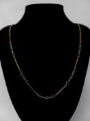 A 14ct yellow gold and sapphire chain necklace interspaced with thirty-three, oval, natural, faceted