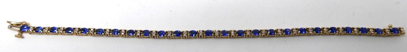 A 14ct yellow gold diamond and tanzanite tennis bracelet set with alternating stones of 50