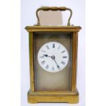 A 20th century brass carriage clock, the engine turned and white enamelled dial with roman numerals,