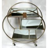 A Art Deco style drinks trolley of circular design, with bevelled mirrored tops, on castors, H.94